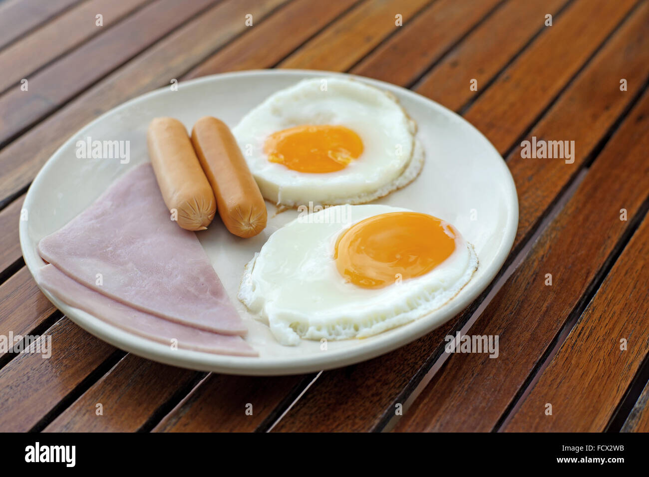 breakfast meal with ham sausage and egg on wooden background Stock Photo