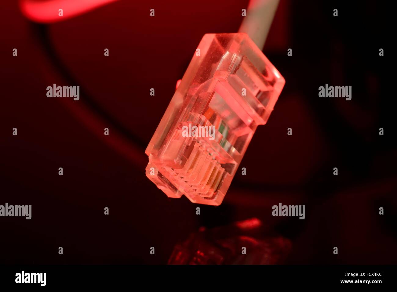 red highlighted internet  rj45 connector on black mirror background Stock Photo