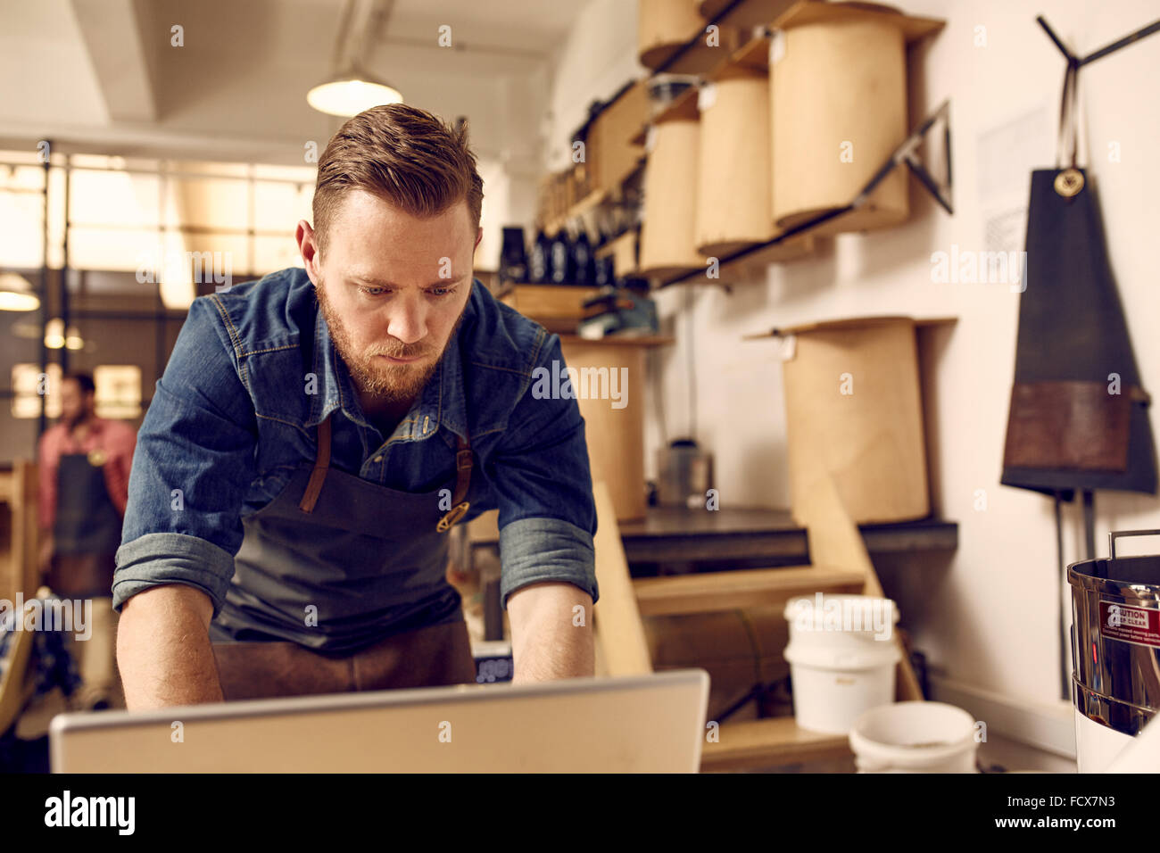 Hipster business owner working on laptop in his modern work Stock Photo