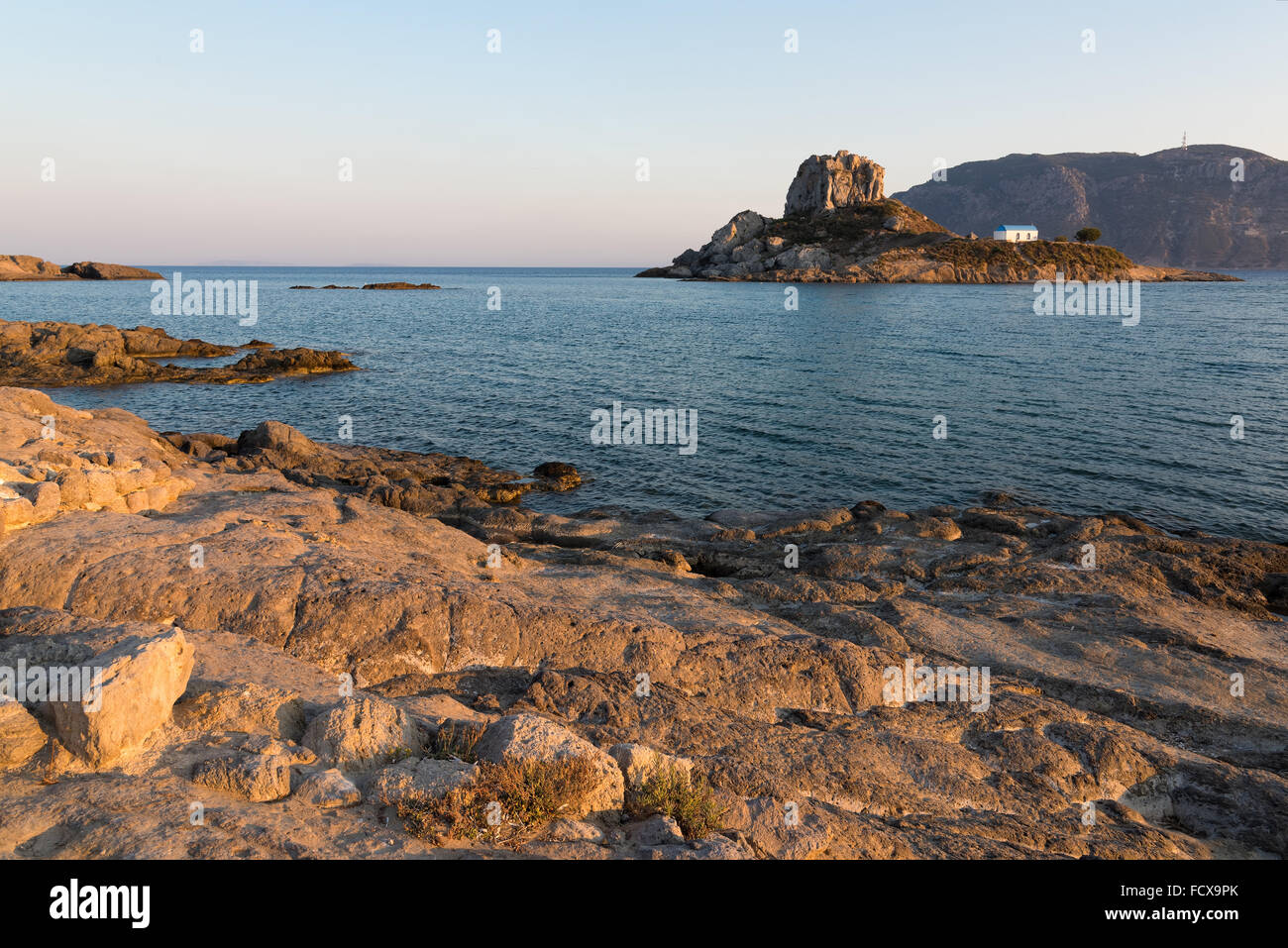 Landscape with rocky coastline and islet at sunset in Kos island, Greece Stock Photo