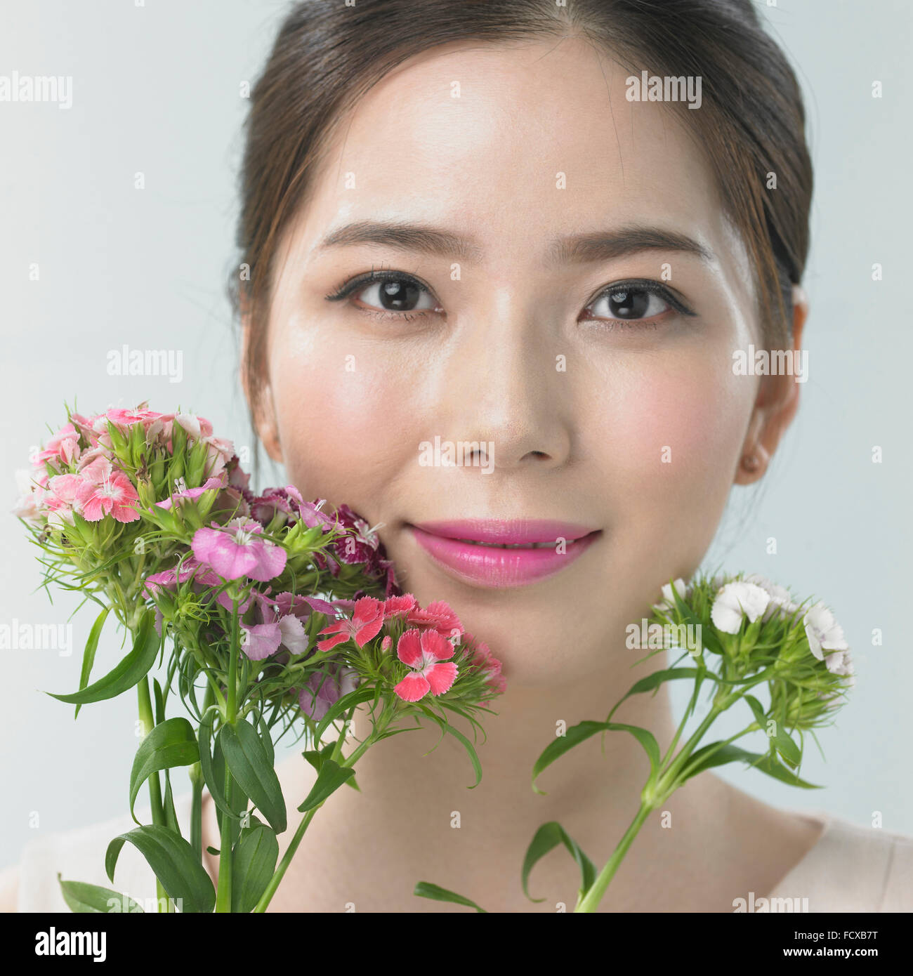 Woman's face with plants with small petals Stock Photo