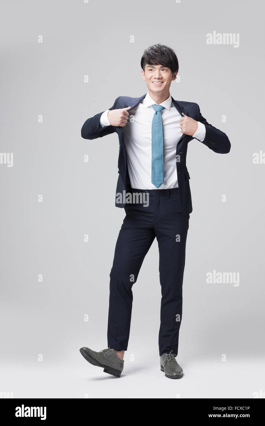 Man in business outfits standing and wearing a black jacket with a smile Stock Photo