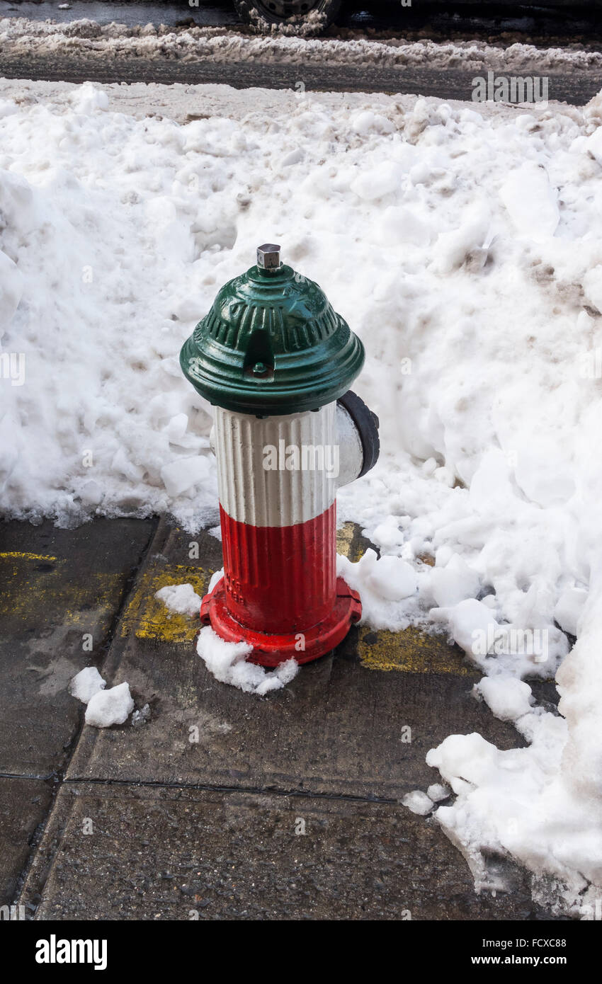 Red, white, and green fire hydrant after Jonas winter snow storm in Little Italy in New York City Stock Photo