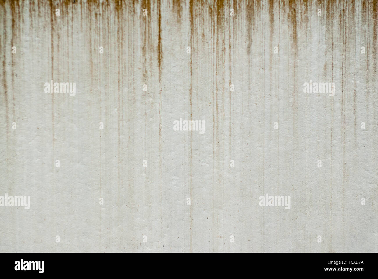 Background of dirty brown streaks dripping vertically on pale gray wall