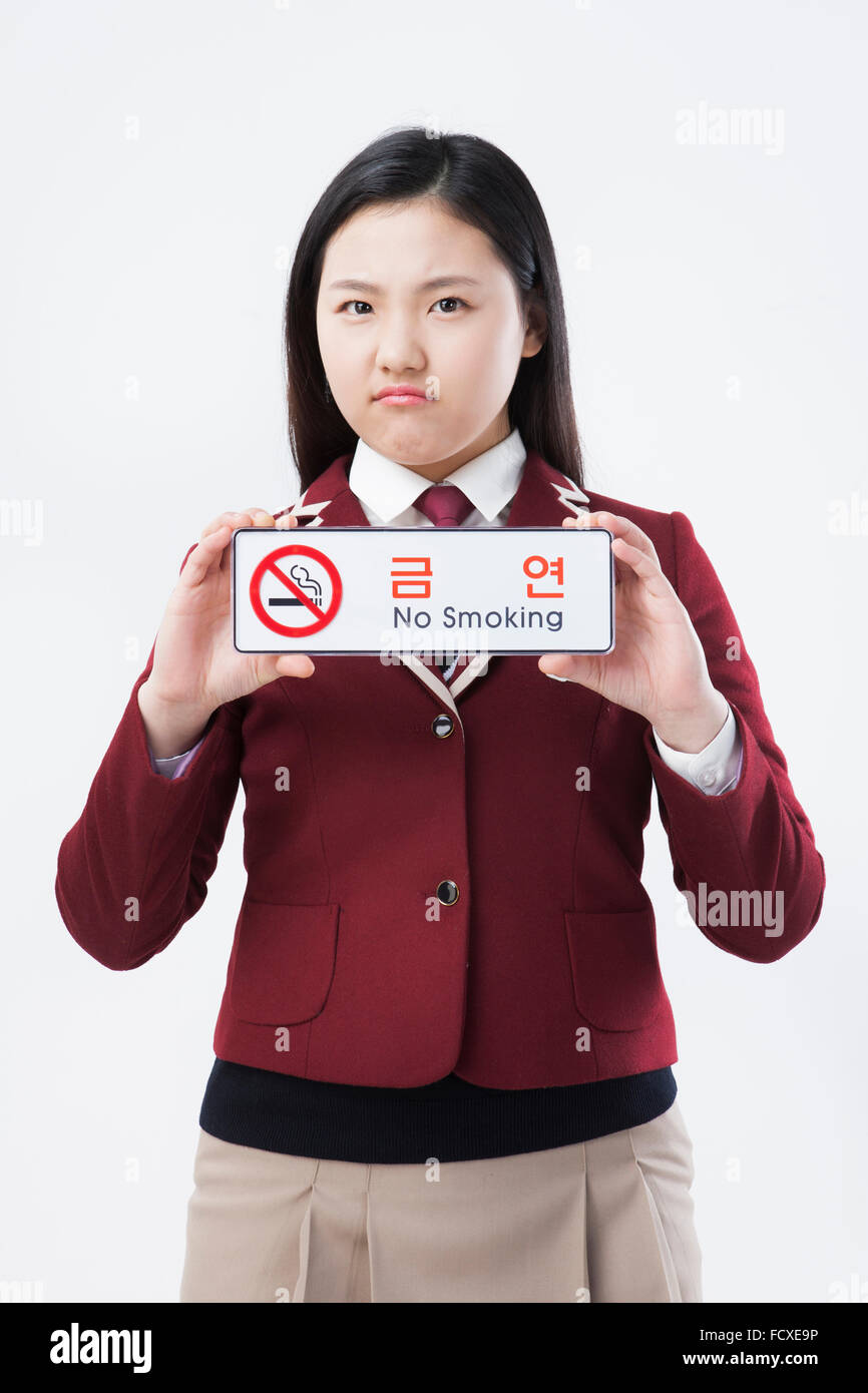 High school girl in school uniform holding No smoking sign in frowning face Stock Photo