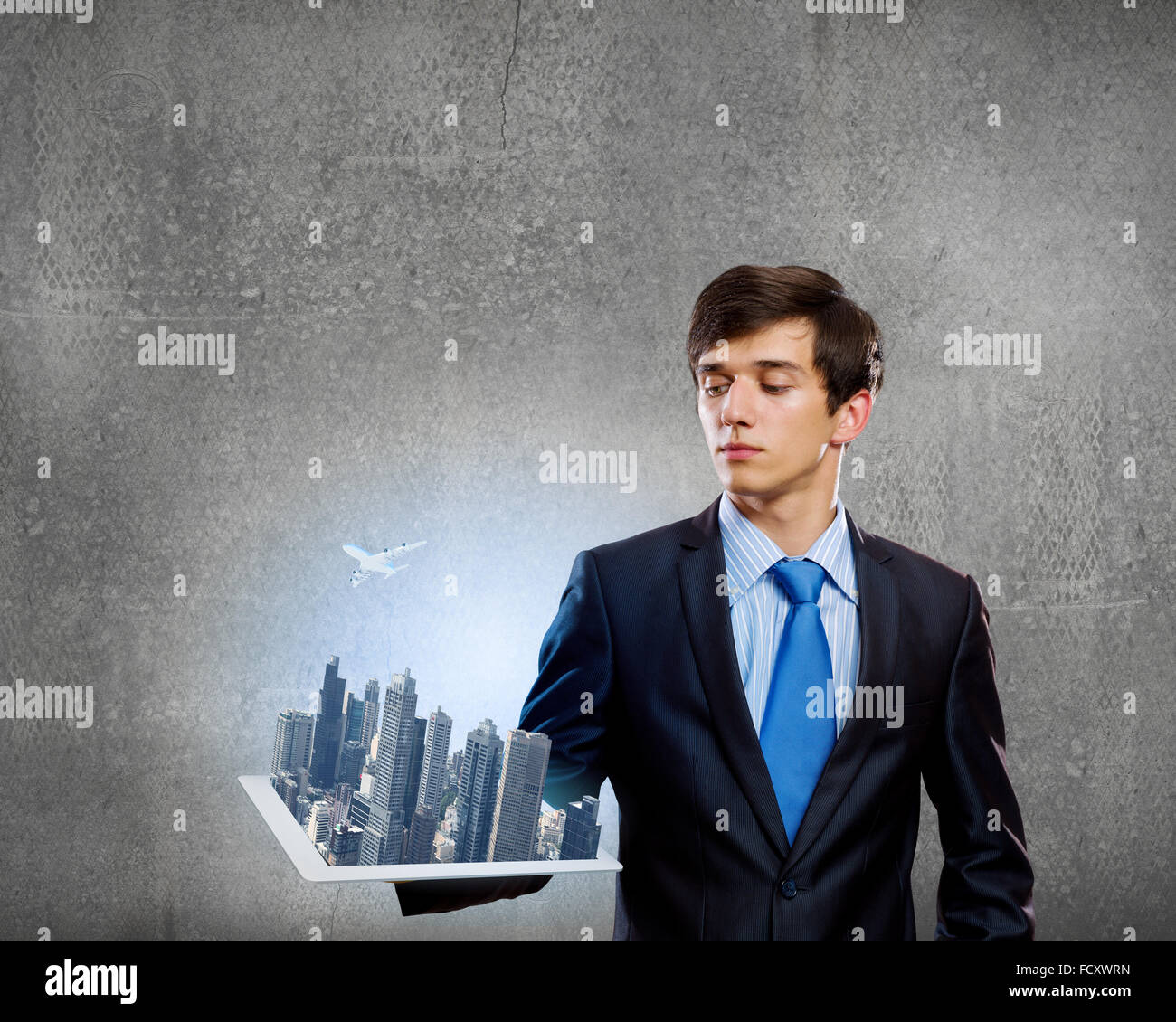 Handsome businessman holding model of modern city Stock Photo - Alamy