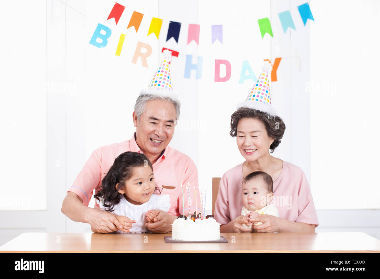 Portrait of old couple with thier grandchildren at birthday party Stock Photo