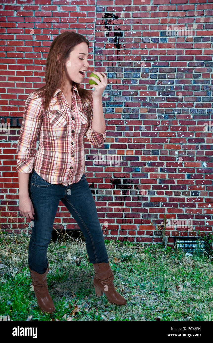 A beautiful young woman eating a frsh delicious apple Stock Photo