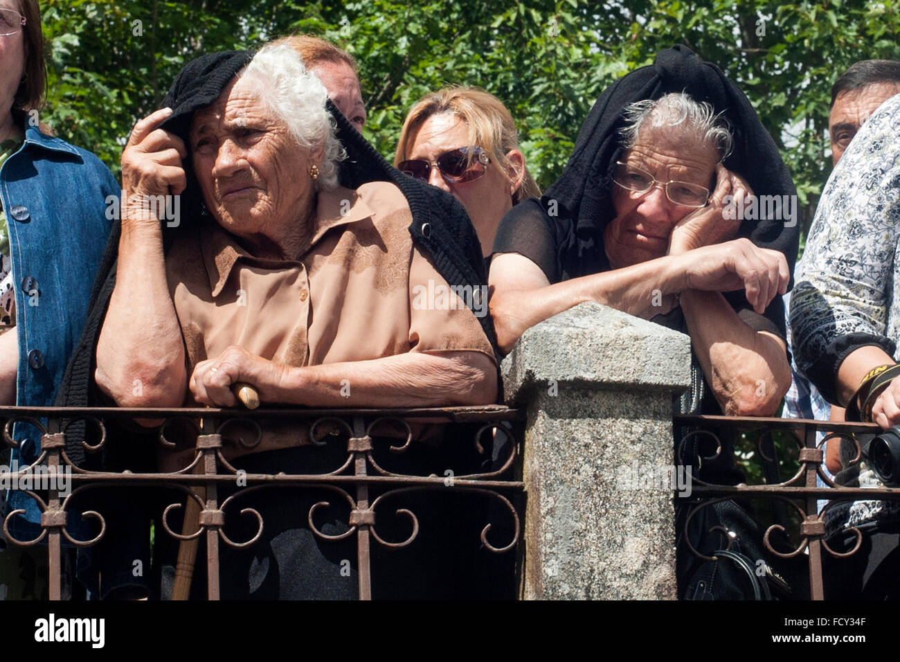 older people are protected from the sun as he could while watching the procession of coffins in Santa Marta de Ribarteme (Pontev Stock Photo