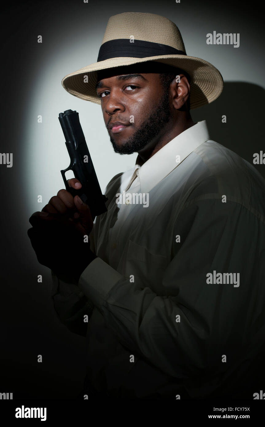 Black African American police private detective man on the job with a gun Stock Photo