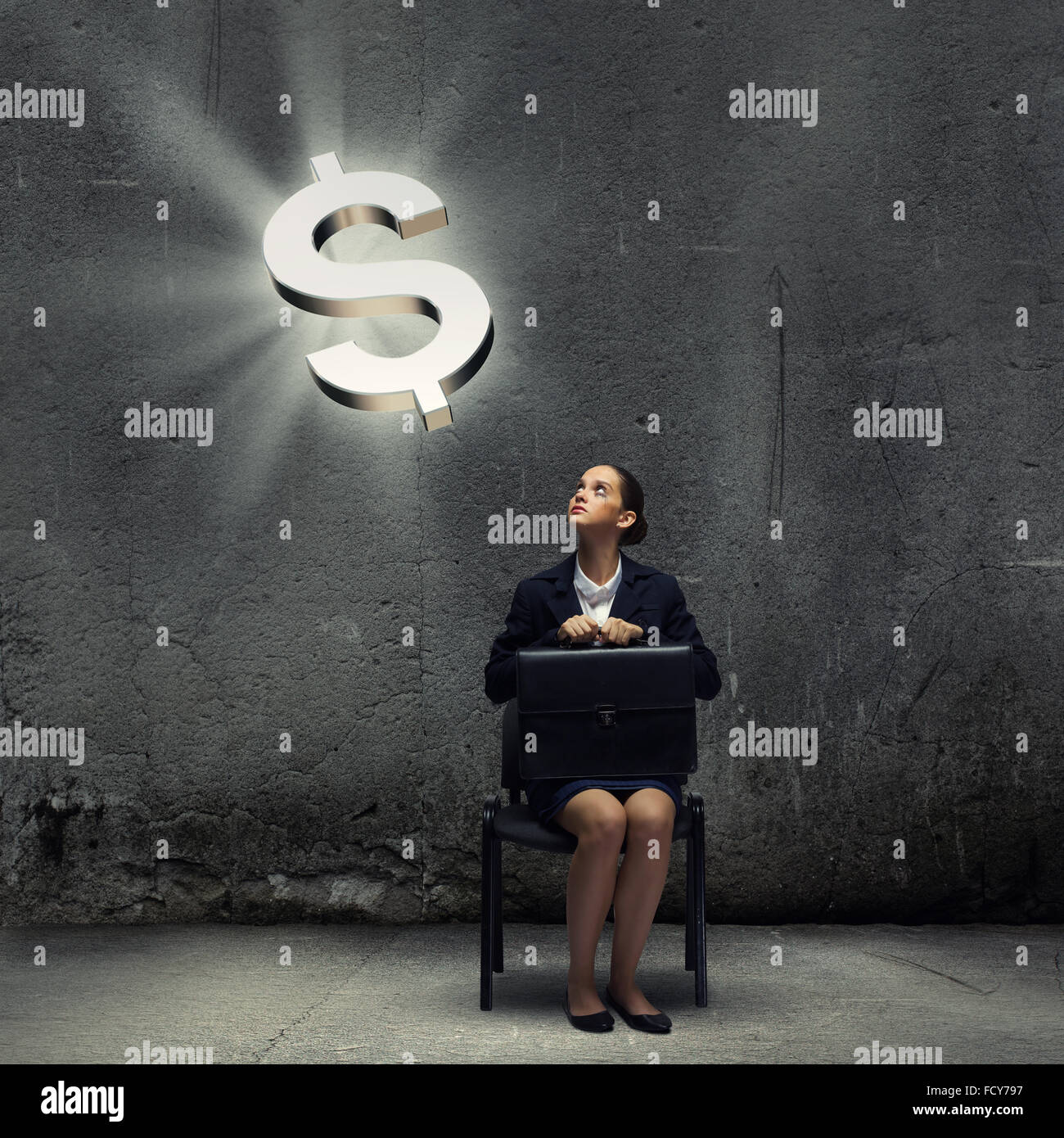 Young businesswoman sitting on chair and looking at dollar symbol above ...