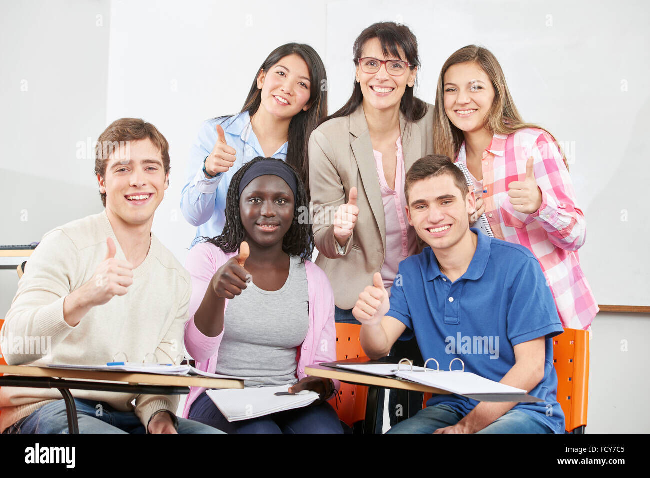 Successful group of students with their thumbs up Stock Photo