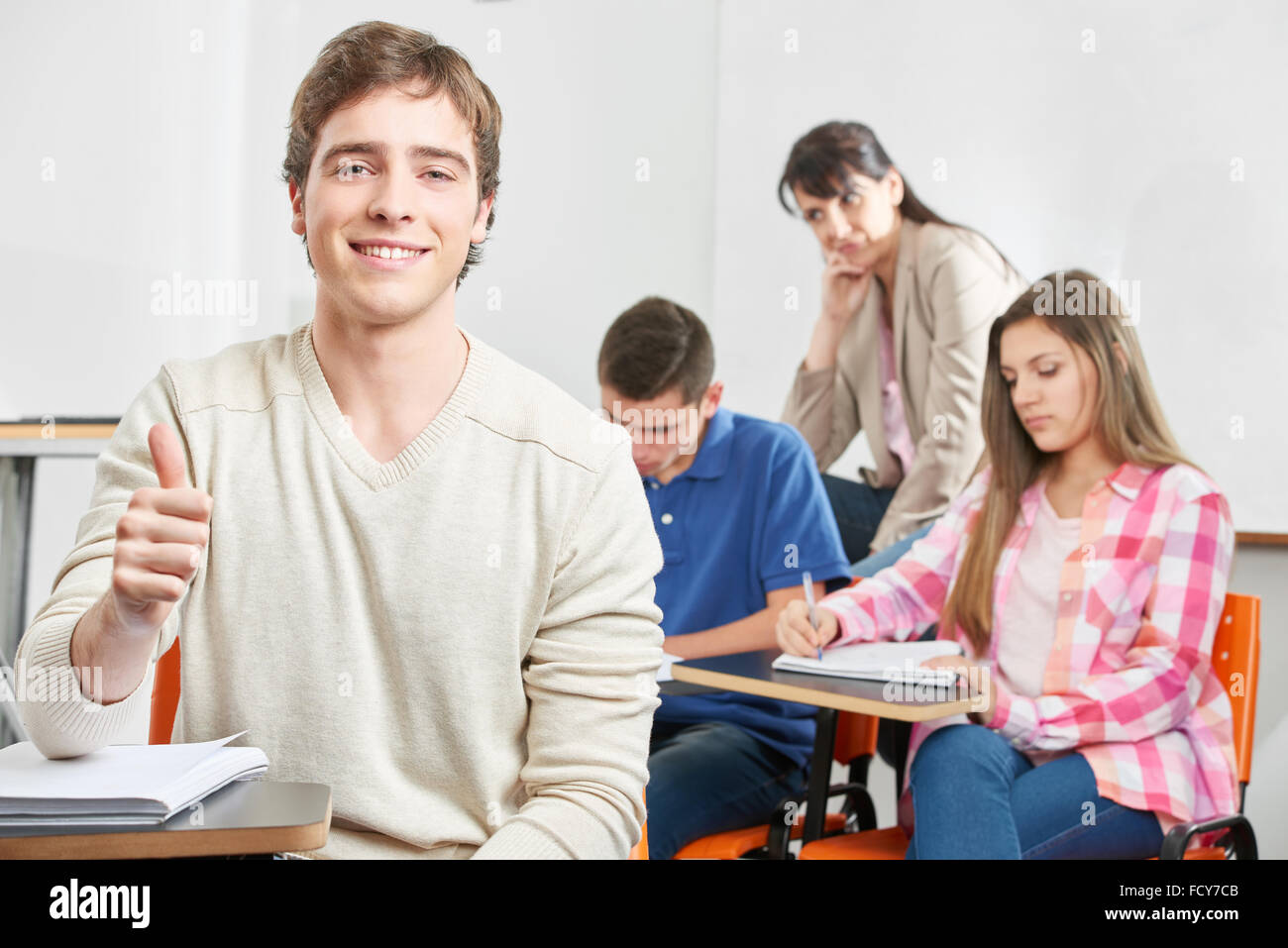 Teenage boy holding his thumb up during a test Stock Photo