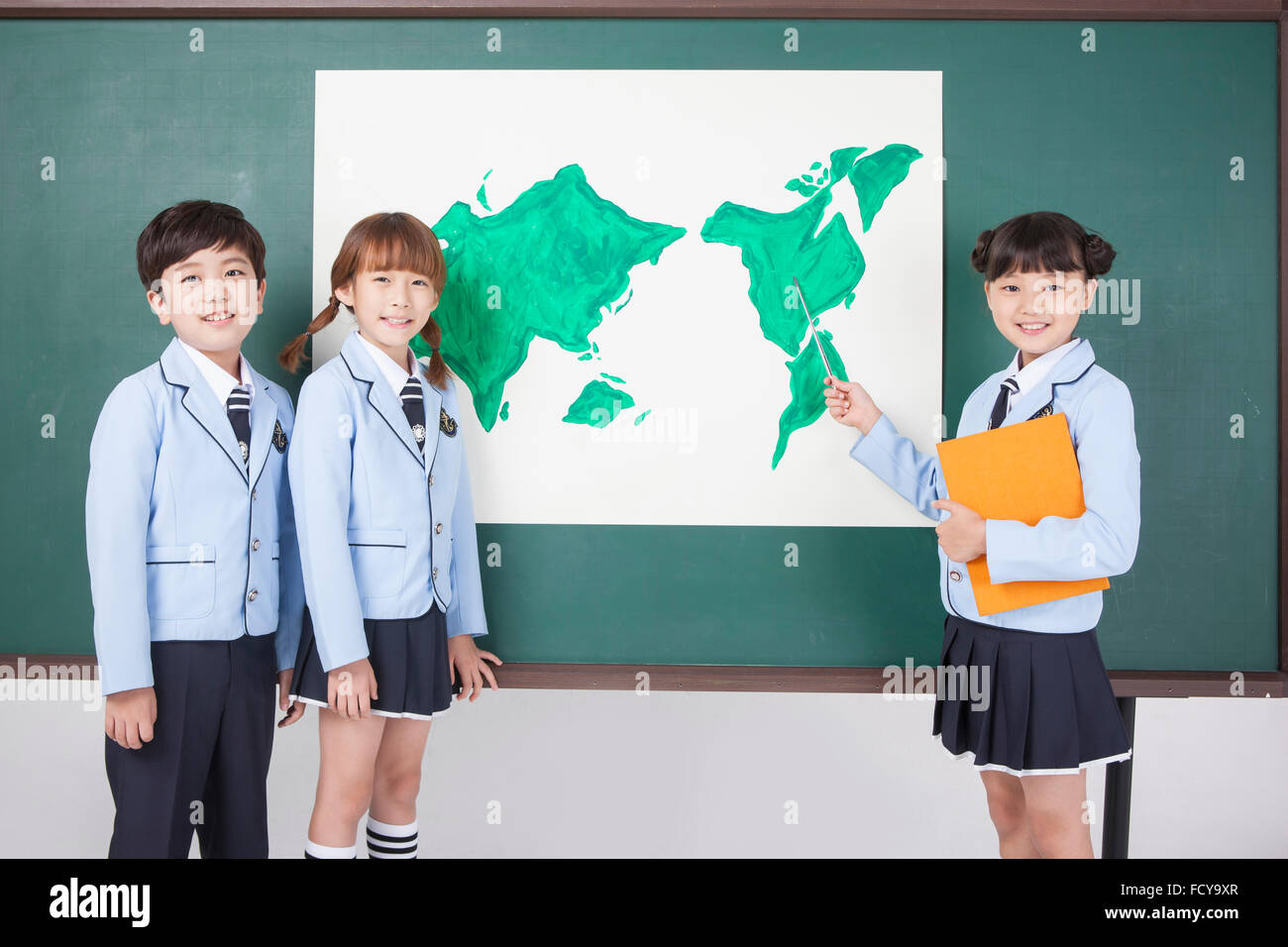 Three elementary school students in school uniforms standing in front