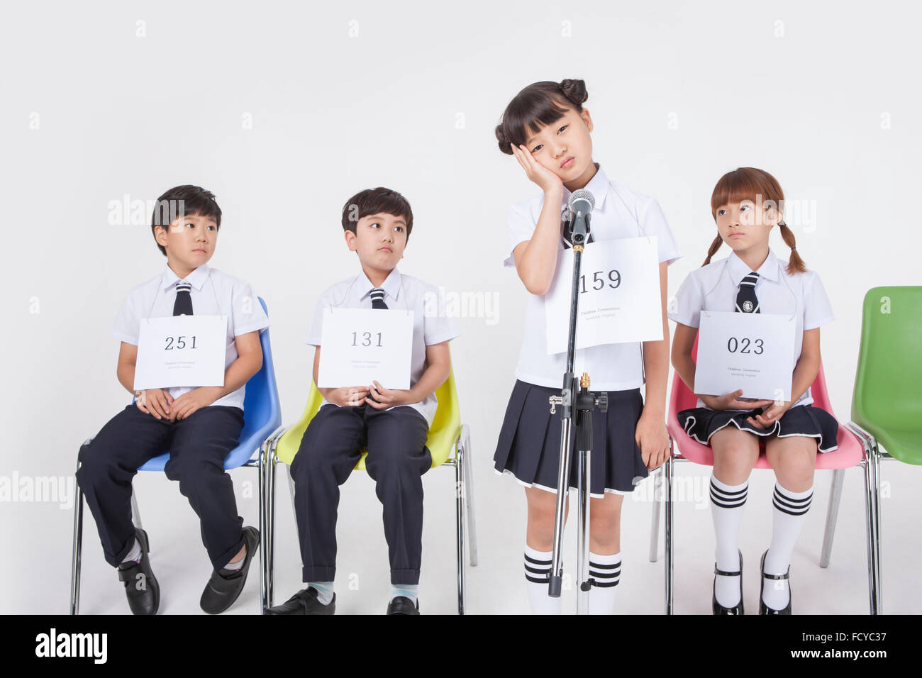 Elementary school girl standing with a microphone in worried face and