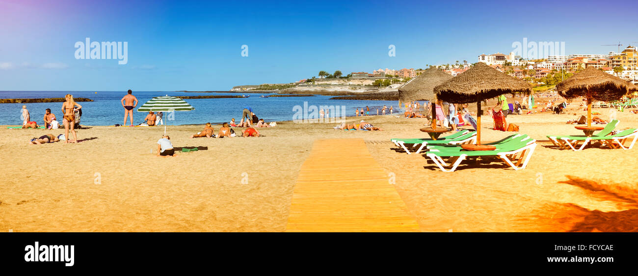 TENERIFE SPAIN JANUARY 14 2013 Sandy Beach With Thatched Parasols tenerife-spain-january-14-2013-sandy-beach-with-thatched-parasols