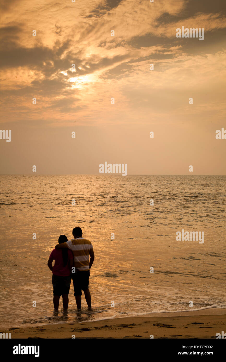 Sunrise, couple, romance, landscape, warm reflections, holidaying, beach, Indian beach, horizon, hope, love pair Stock Photo