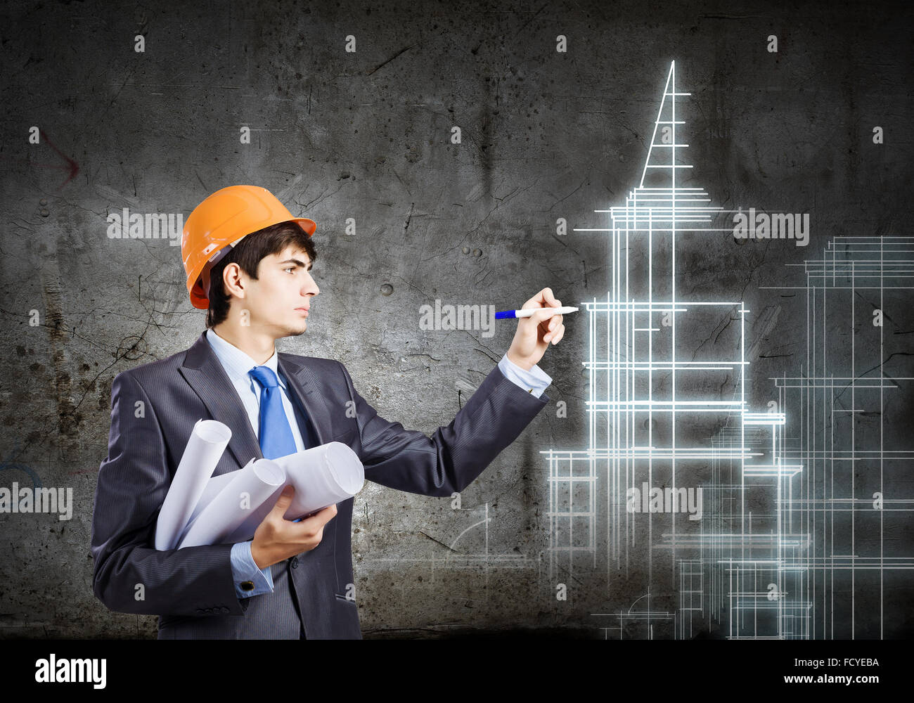 Young man engineer in helmet drawing construction project Stock Photo ...