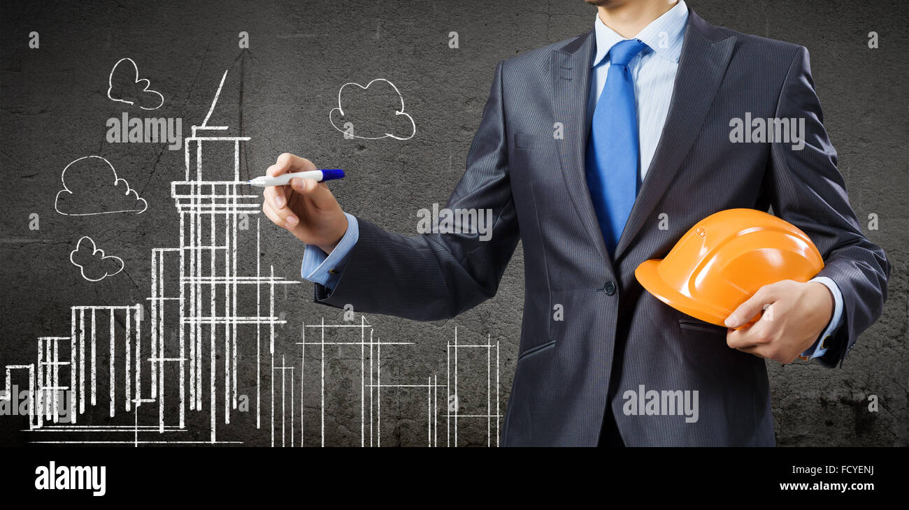 Young man engineer in helmet drawing construction project Stock Photo ...