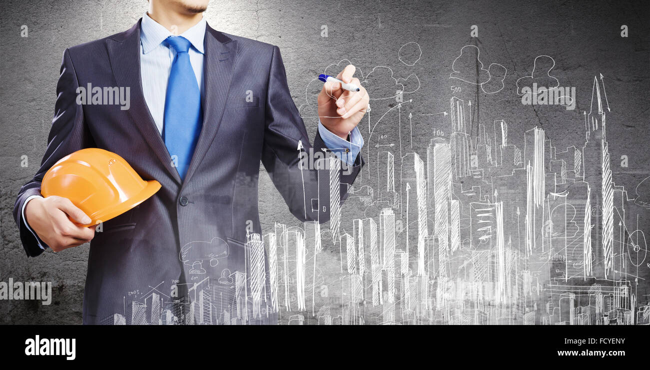 Young man engineer in helmet drawing construction project Stock Photo ...