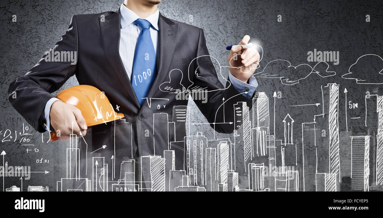 Young man engineer in helmet drawing construction project Stock Photo ...