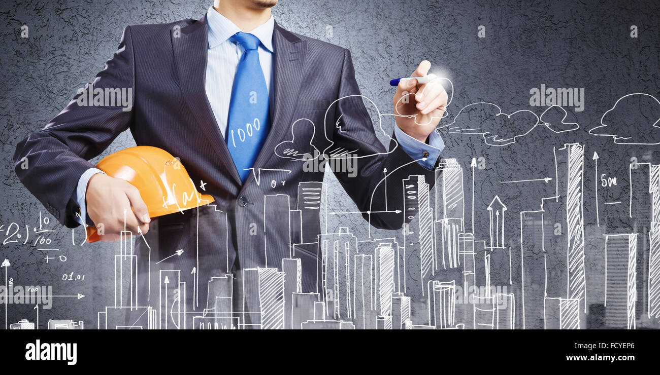 Young man engineer in helmet drawing construction project Stock Photo ...