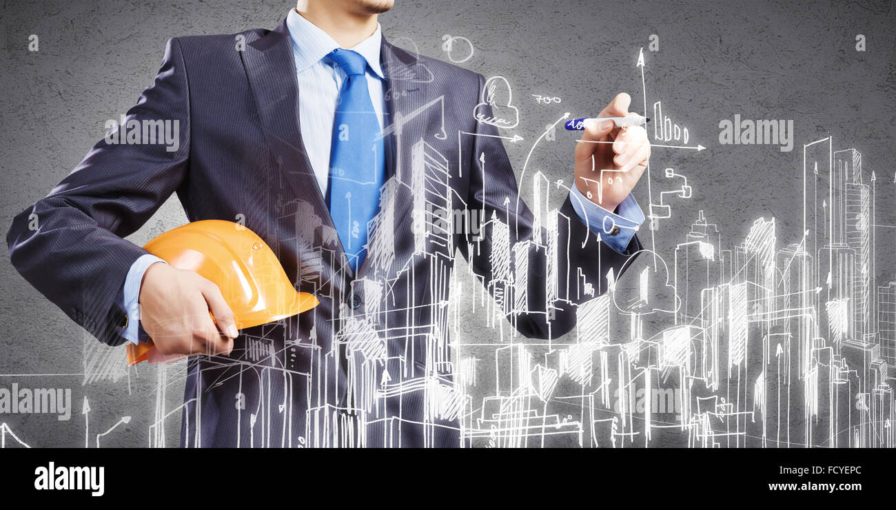 Young man engineer in helmet drawing construction project Stock Photo ...
