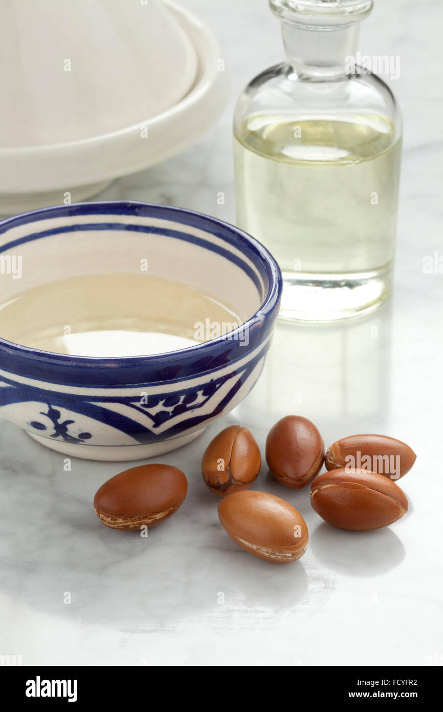 Cup with Moroccan argan oil and nuts for cosmetics Stock Photo