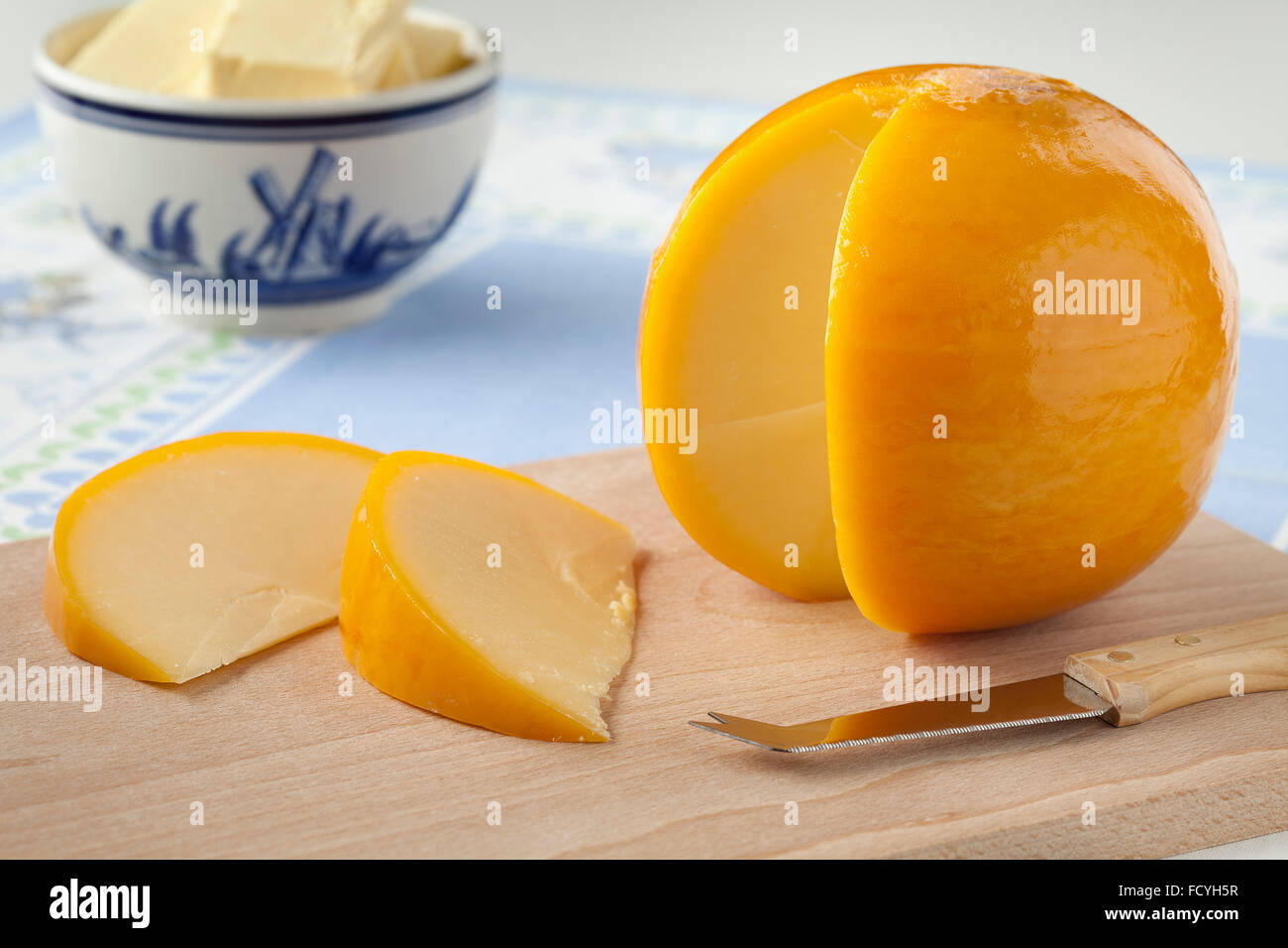 Yellow round Edam cheese with slices on a cutting board Stock Photo Alamy