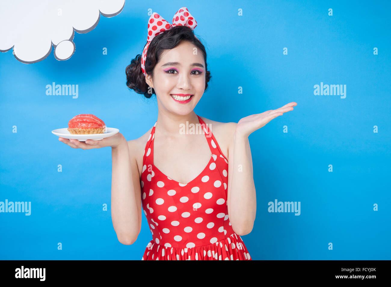 Copy space of a white thinking bubble with a woman in retro style holding a food plate on her hand and staring forward with a Stock Photo