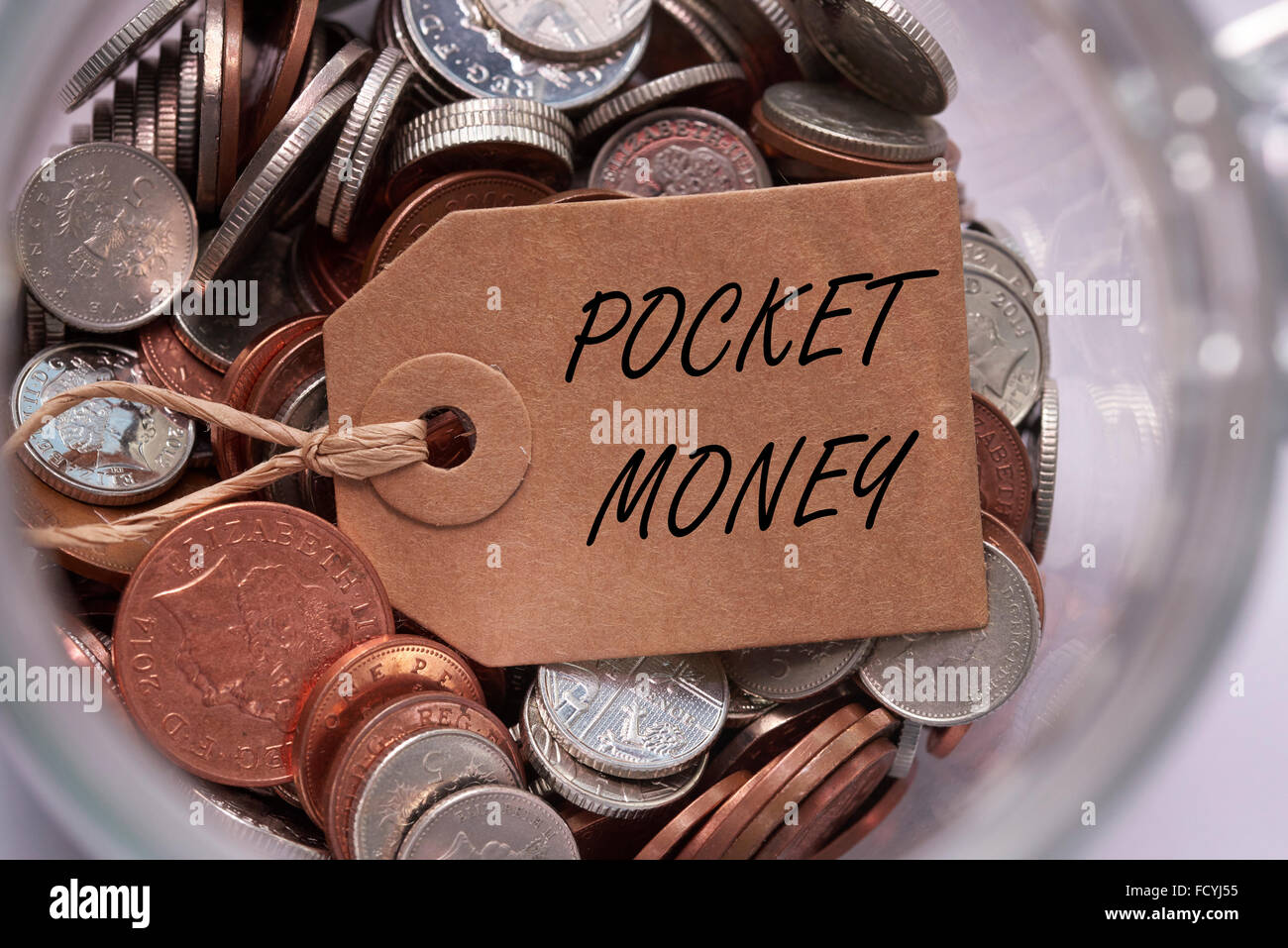 Pocket money label on British mixed coins inside a glass jar concept Stock Photo