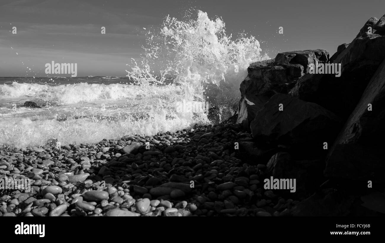 OLYMPUS DIGITAL CAMERA Waves Crashing on Shoreline with Pebbles Stock Photo