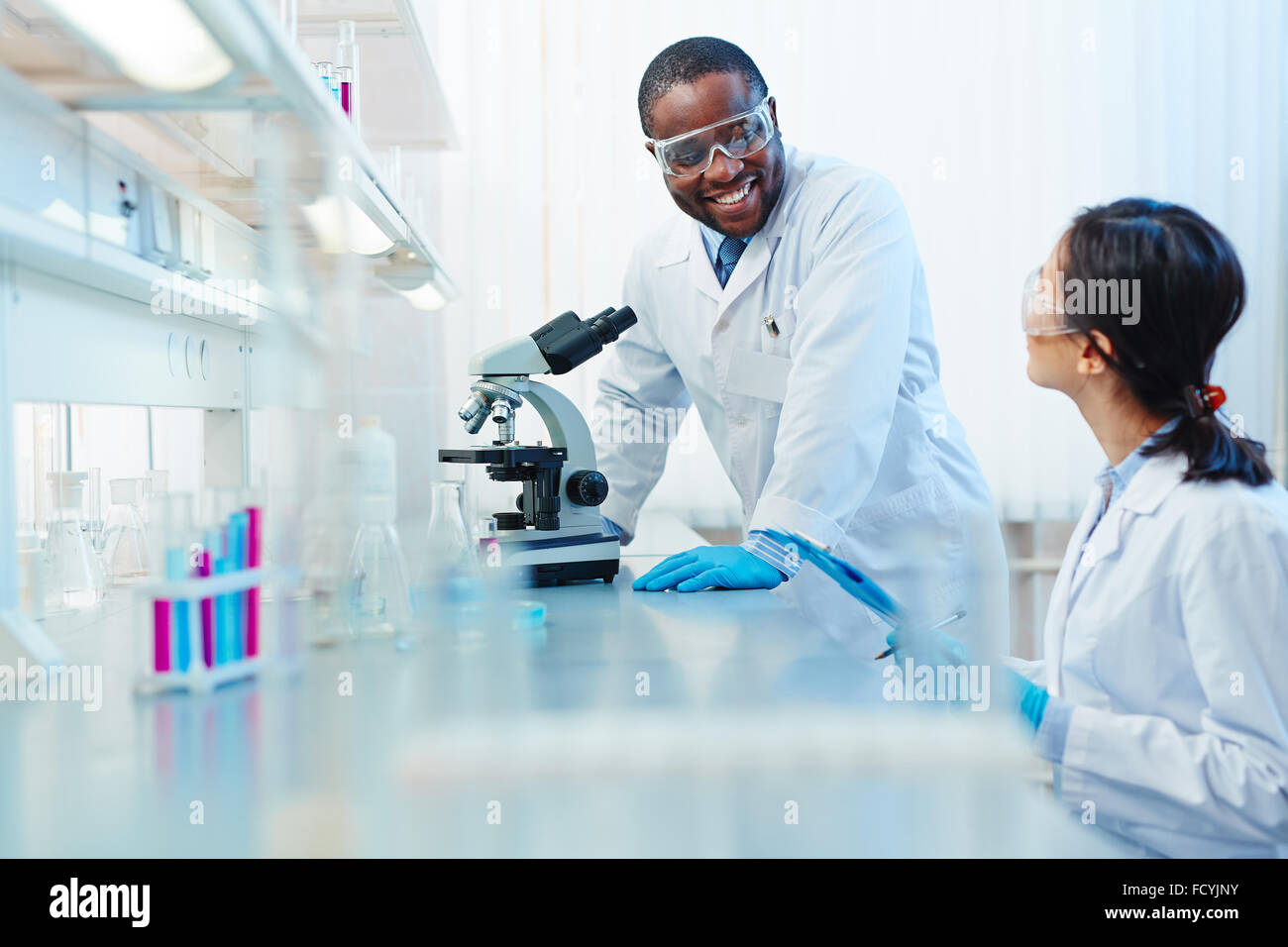 Modern biochemists working together in scientific laboratory Stock