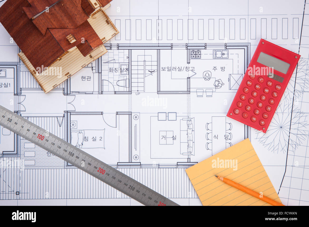 High angle of drafting and designing related objects with a miniature house on a blueprint Stock Photo