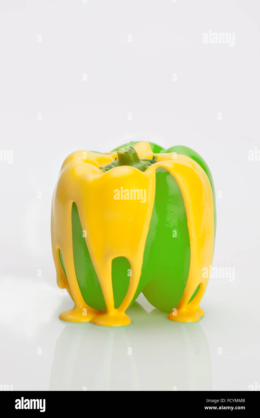 Yellow paint falling in drop on green sweet pepper Stock Photo