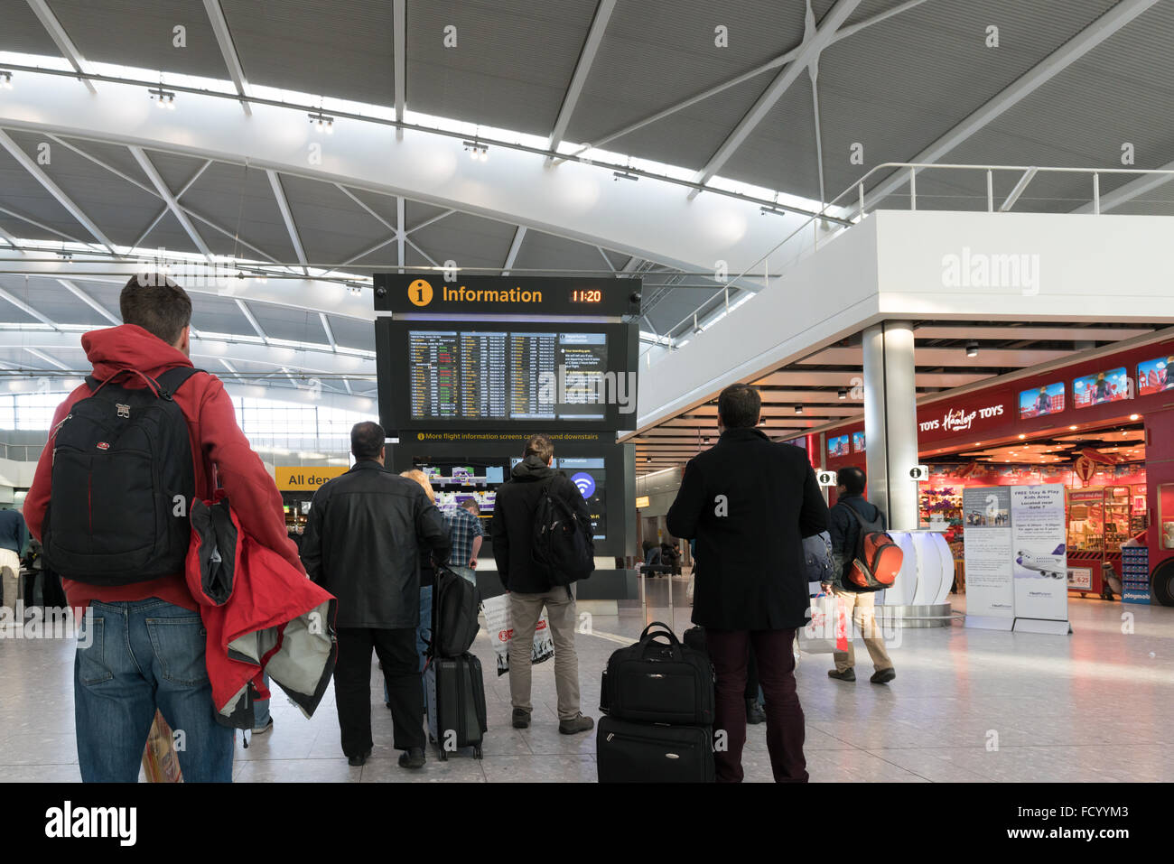 London's Heathrow Airport. Terminal 5. Travelers looking at flight information. Stock Photo