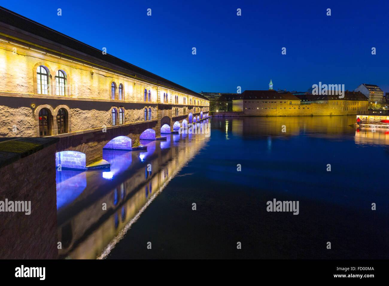 illumined Barrage Vauban at twilight reflected in the waters of the River Ill, Alsace France Stock Photo