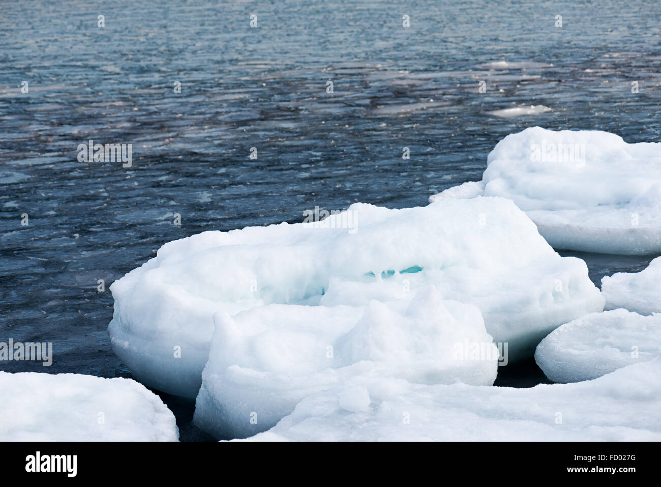 Natural sea ice blocks breaking up against shore and ice during