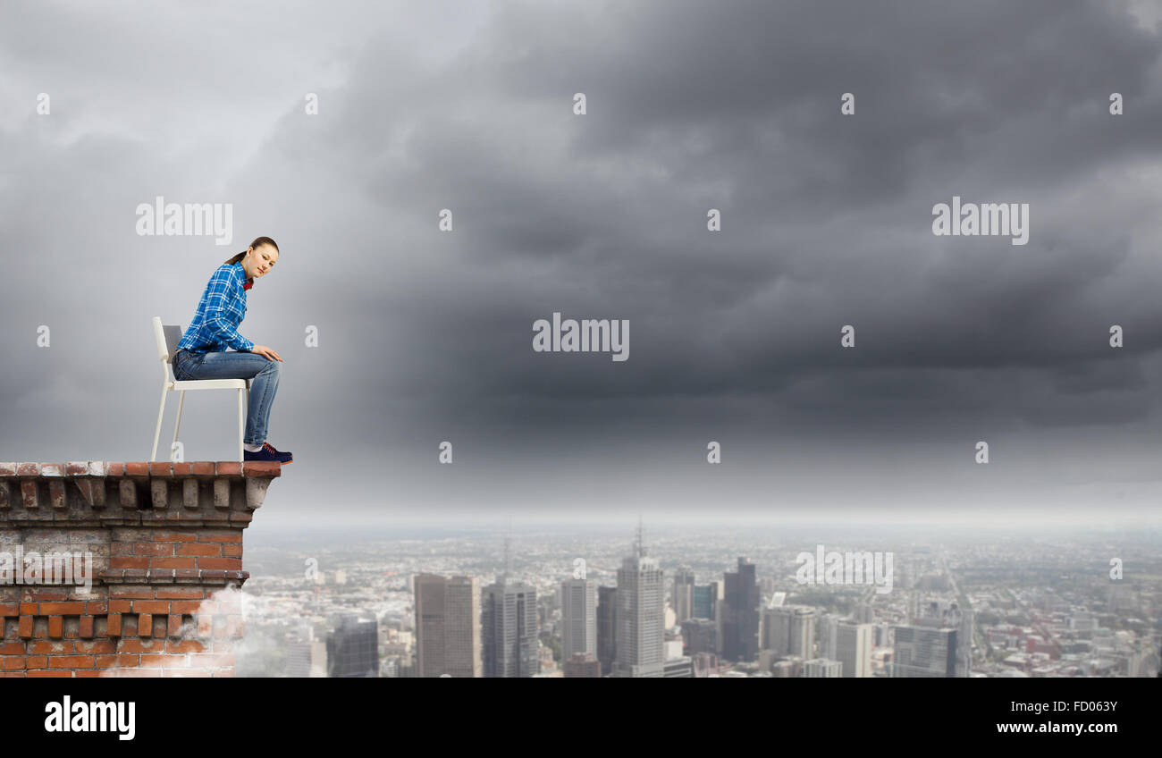 Young woman in casual sitting on in chair on top of building Stock ...