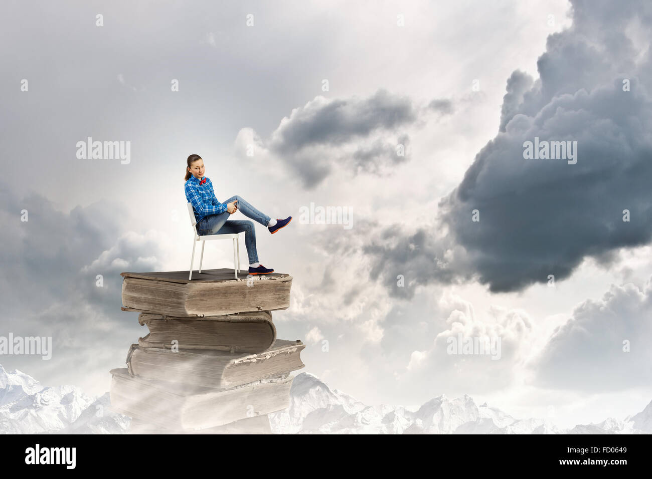 Young girl sitting on high pile of books Stock Photo - Alamy