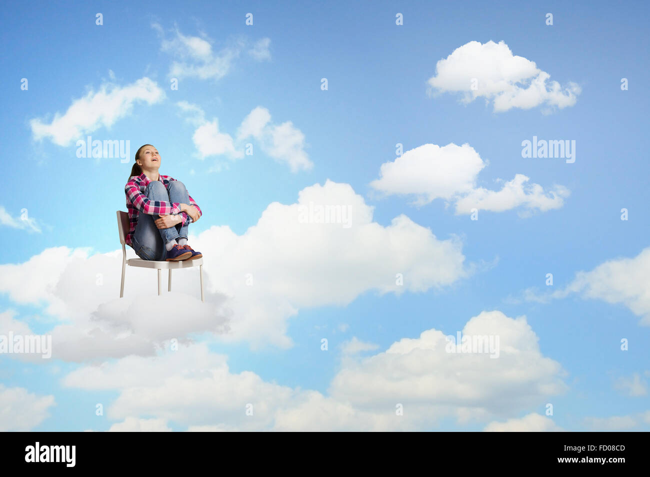 Young woman sitting in chair on cloud high in sky Stock Photo - Alamy