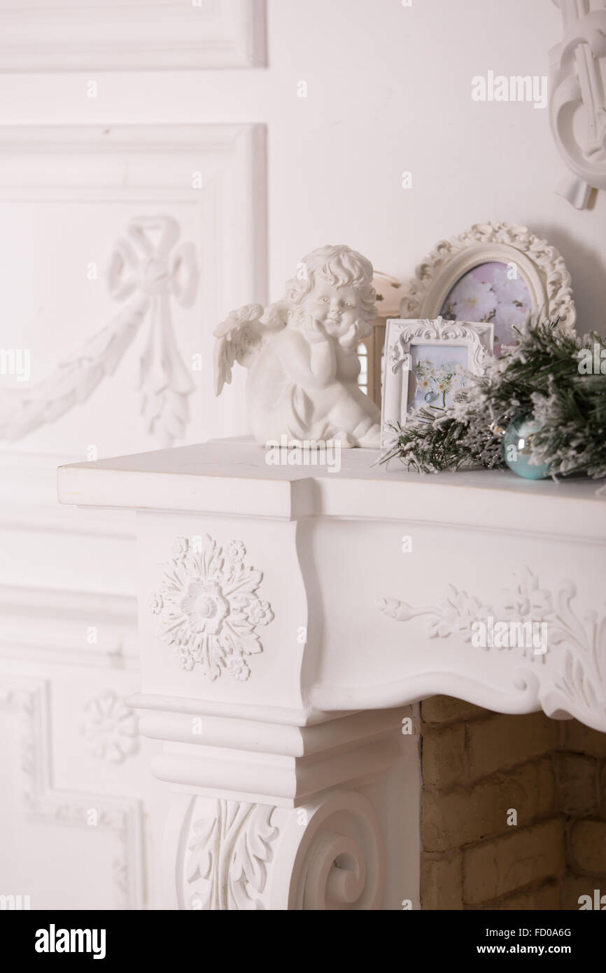 white framework for photos and a figurine of an angel in a white interior Stock Photo