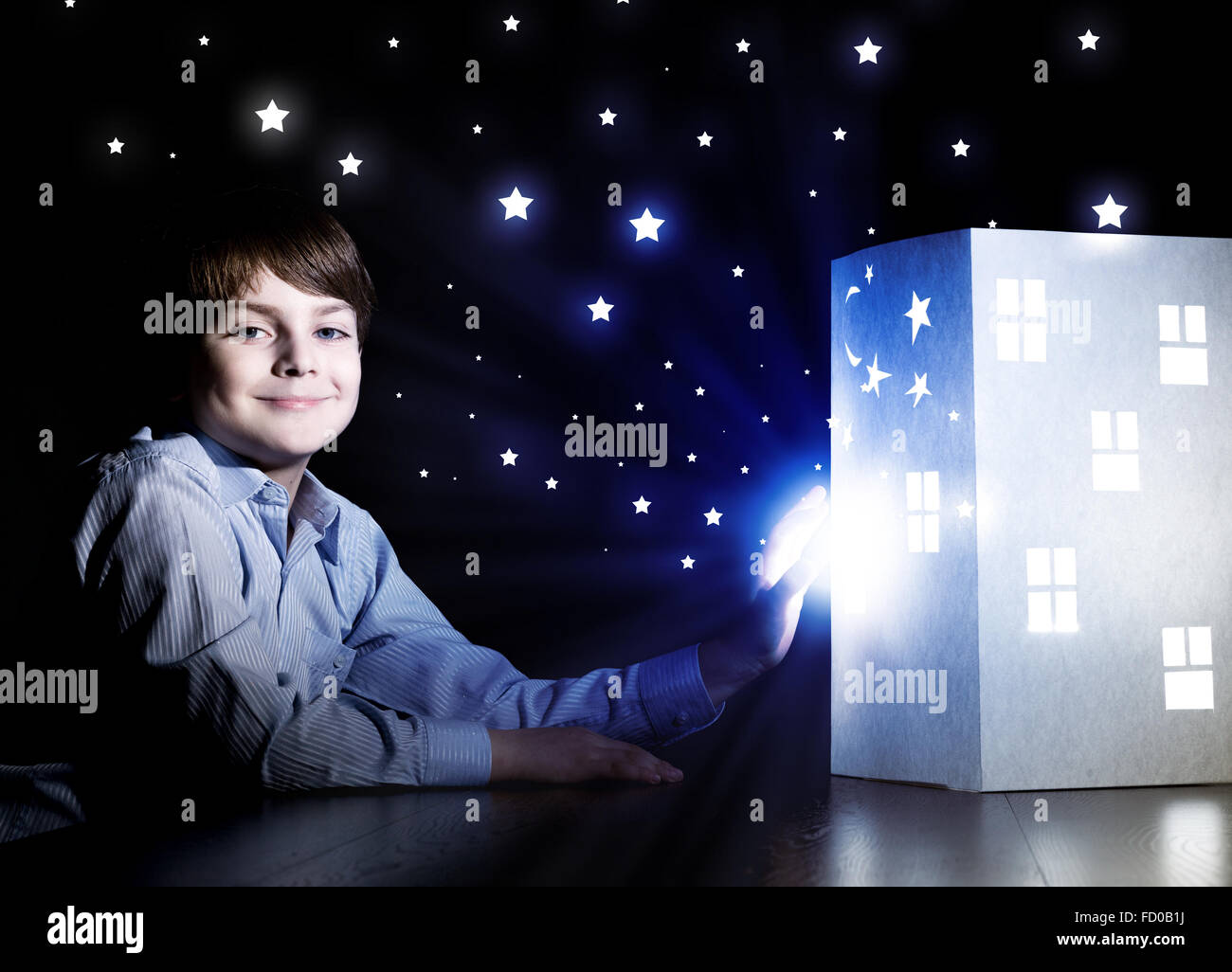 Cute little boy looking at model of house Stock Photo - Alamy
