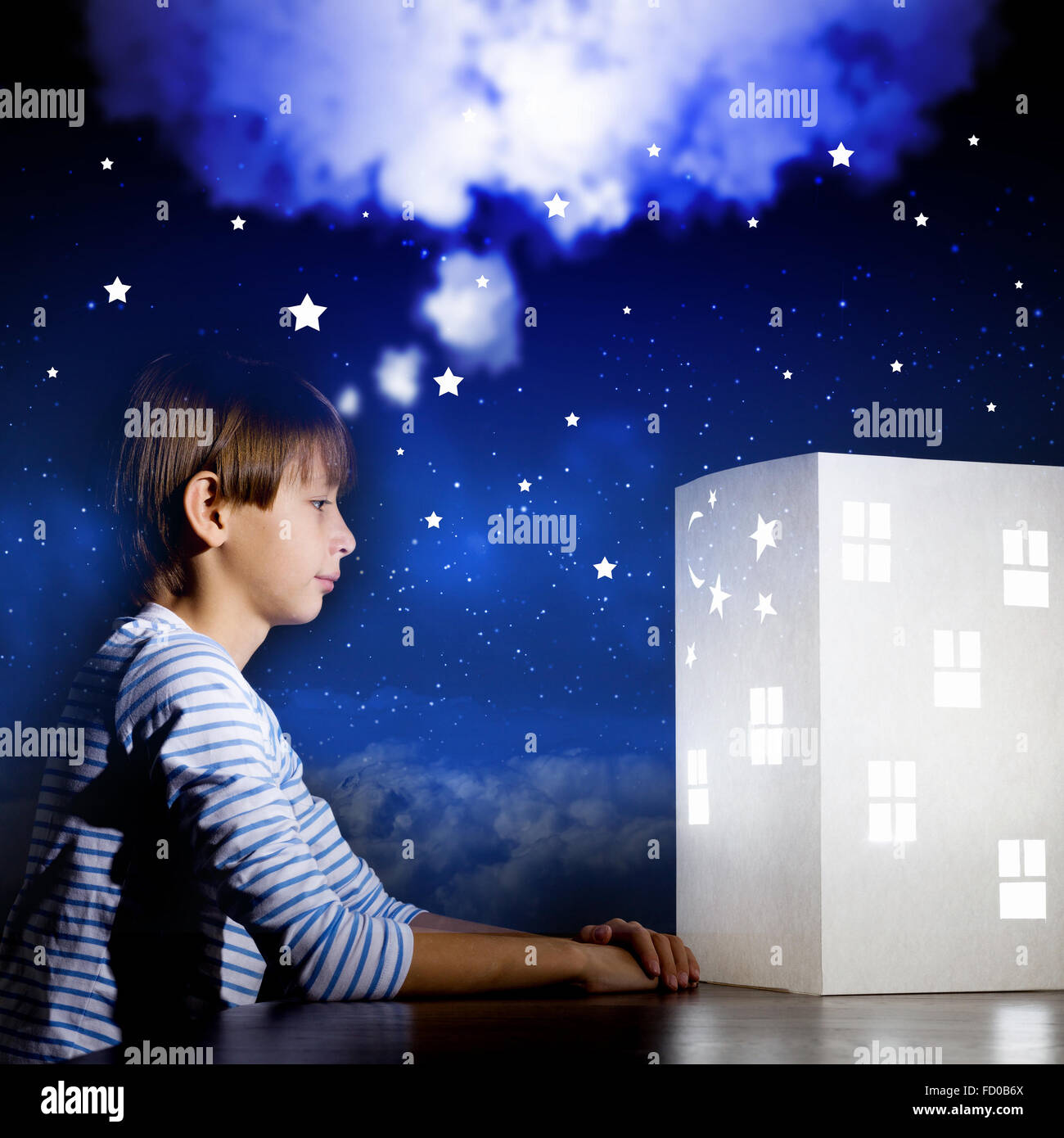 Cute little boy looking at model of house Stock Photo - Alamy
