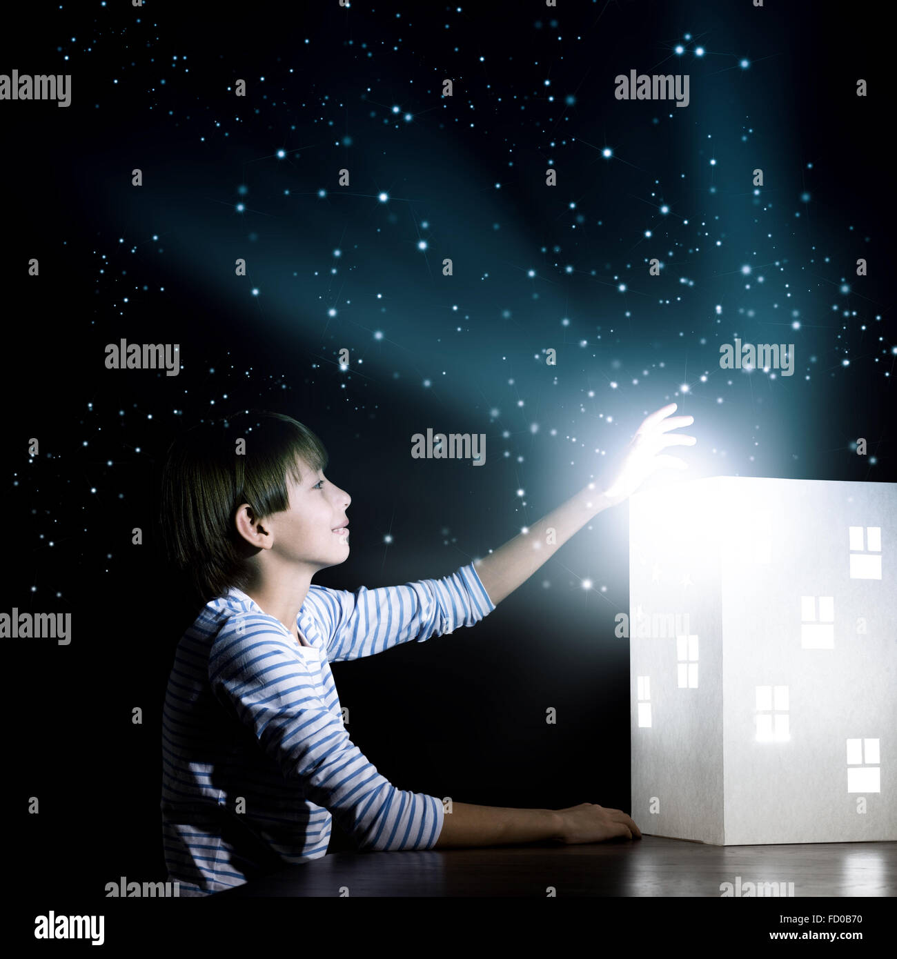 Cute little boy looking at model of house Stock Photo - Alamy
