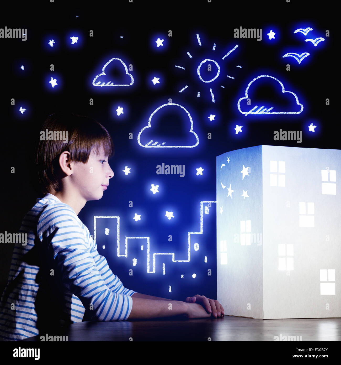Cute little boy looking at model of house Stock Photo - Alamy