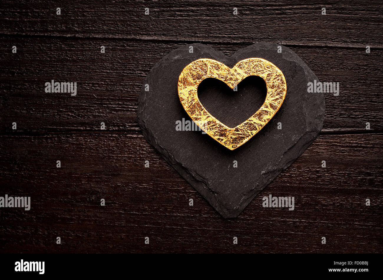Golden heart on dark wooden background Stock Photo