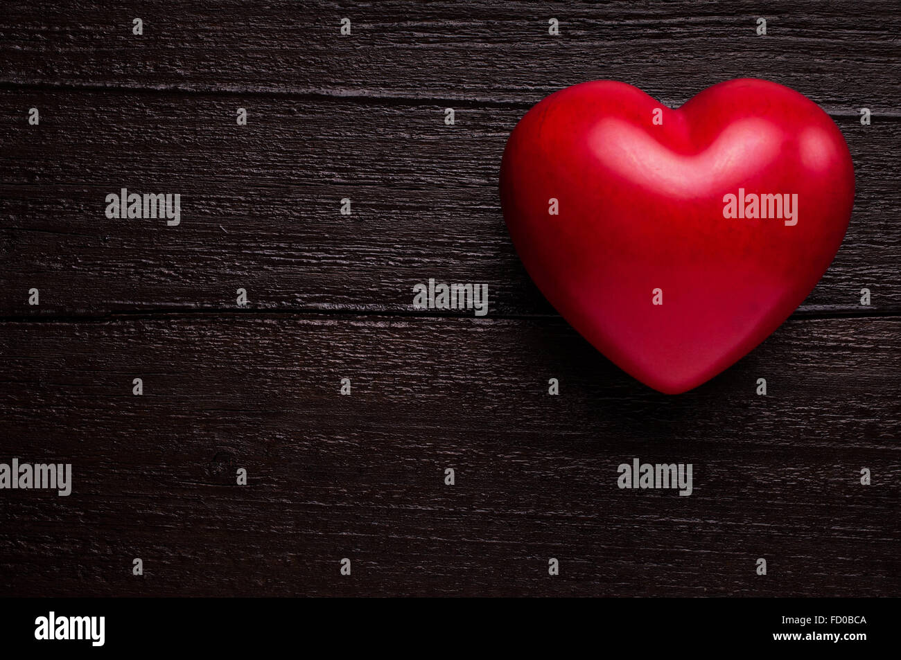 Red heart on a dark-brown wooden background Stock Photo - Alamy