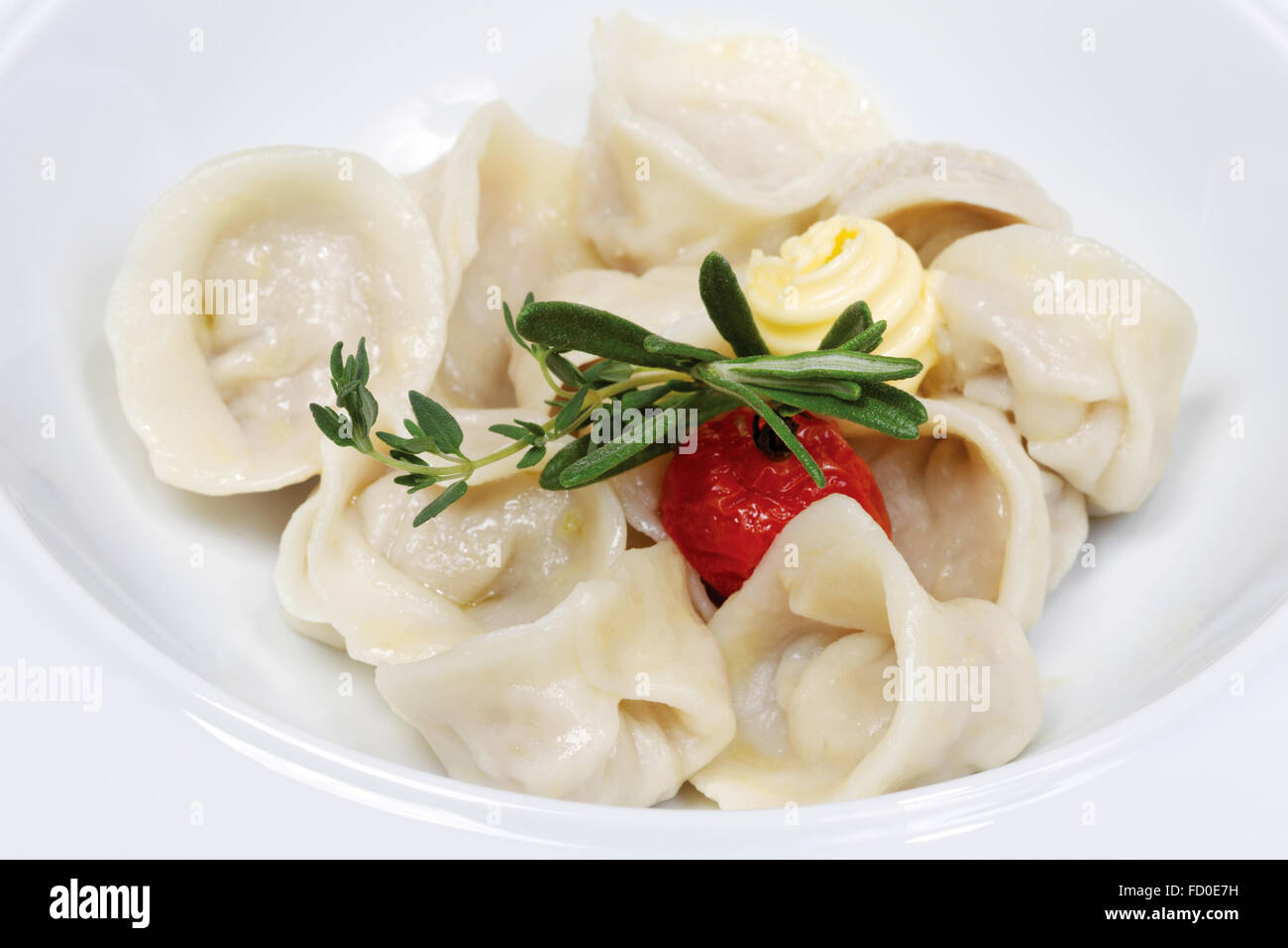 Dumplings with butter - russian pelmeni - italian ravioli - on white plate Stock Photo
