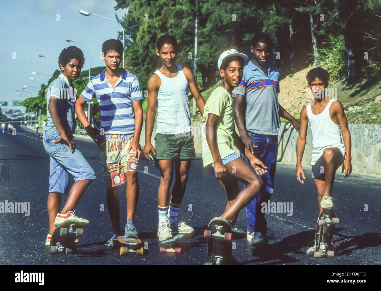 CARACAS, VENEZUELA - Six boys pose on their skateboards. 1988 Stock Photo